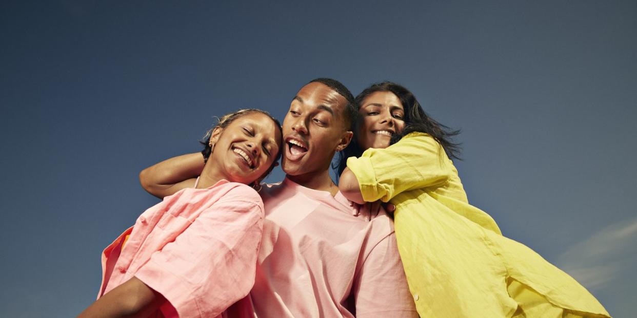 low angle view of carefree male and female friends enjoying against sky