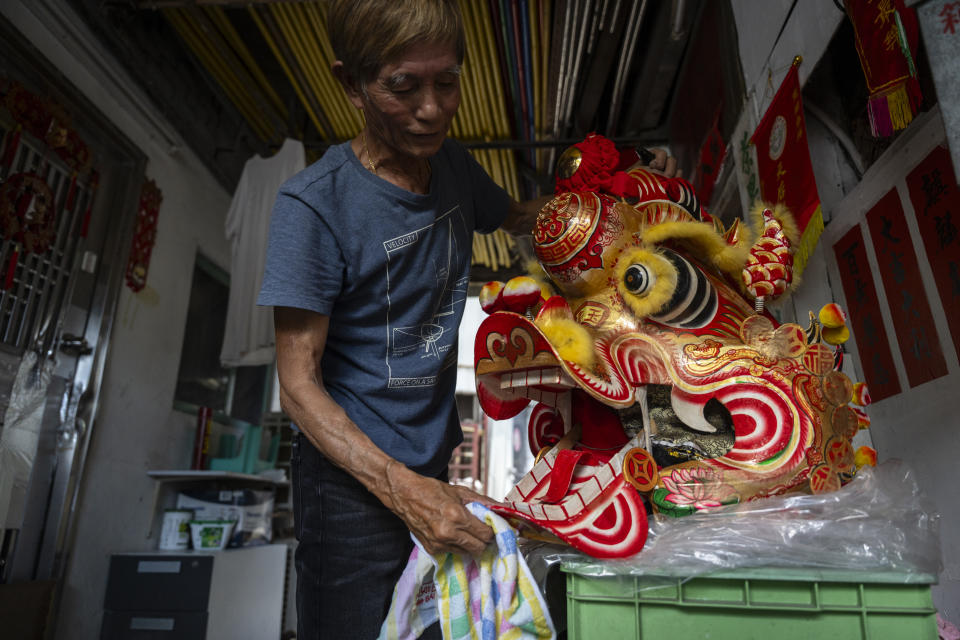 Villager Lo Yuet-ping cleans the head prop that's used in the traditional "Qilin" Dance at the Cha Kwo Ling village in east Kowloon, Hong Kong, Sunday, Aug. 25, 2024. (AP Photo/Chan Long Hei)