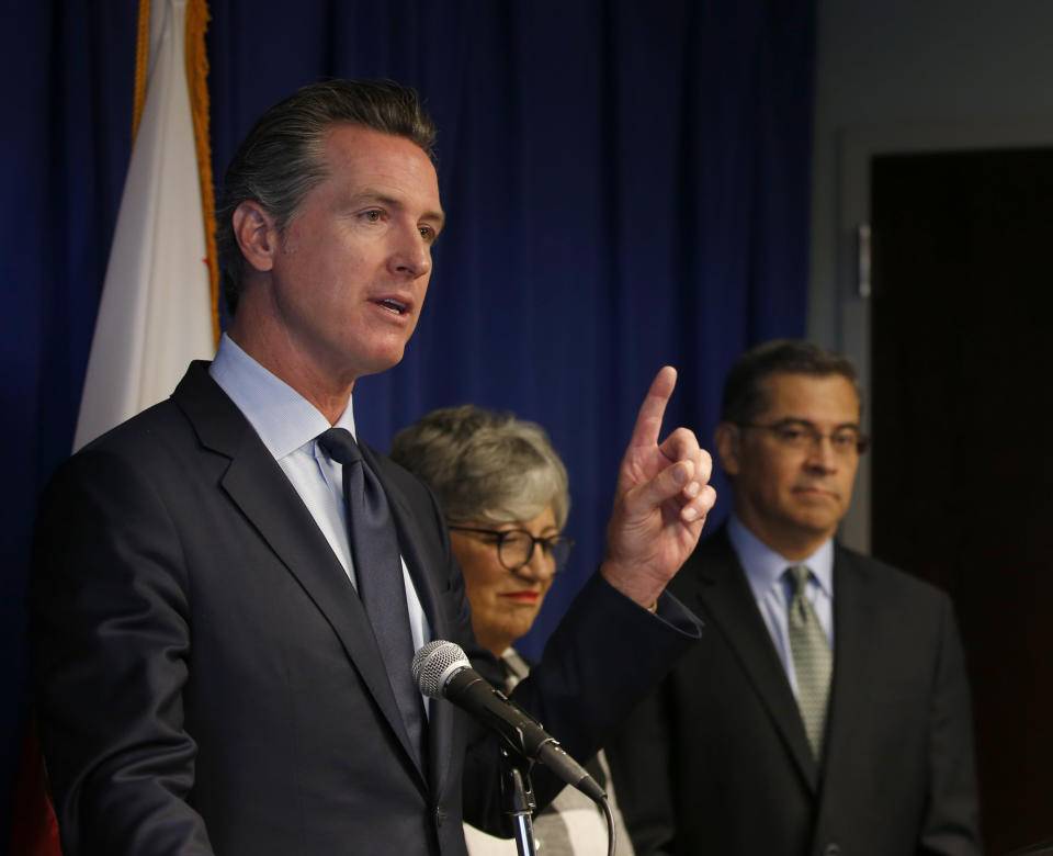 Gov. Gavin Newsom, left, flanked by California Air Resources Board Chair Mary Nichols and California Attorney General Xavier Becerra, discusses the Trump administration's pledge to revoke California's authority to set vehicle emissions standards that are different than the federal standards, during a news conference in Sacramento, Calif., Wednesday, Sept. 18, 2019. (AP Photo/Rich Pedroncelli)