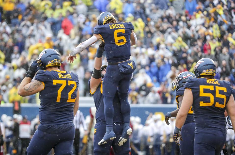 Nov 12, 2022; Morgantown, West Virginia, USA; West Virginia Mountaineers quarterback Garrett Greene (6) celebrates with teammates after running the ball for a touchdown during the second quarter against the Oklahoma Sooners at Mountaineer Field at Milan Puskar Stadium. Mandatory Credit: Ben Queen-USA TODAY Sports