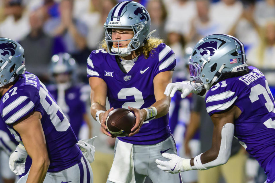 Kansas State quarterback Avery Johnson (2) hands the football off to running back DJ Giddens (31) during an NCAA football game against BYU, Saturday, Sept. 21, 2024, in Provo, Utah. (AP Photo/Tyler Tate)