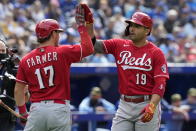 Cincinnati Reds' Joey Votto (19) celebrates his solo home run against the Toronto Blue Jays with teammate Kyle Farmer (17) during eighth-inning baseball game action in Toronto, Sunday, May 22, 2022. (Frank Gunn/The Canadian Press via AP)