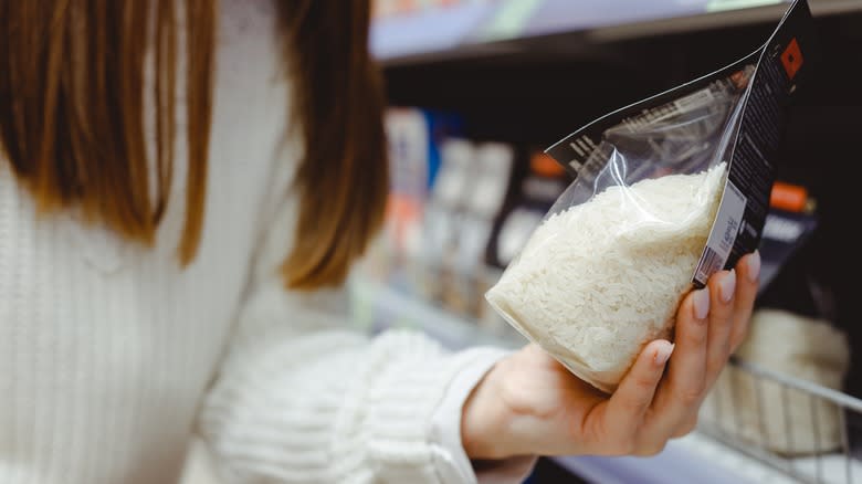 woman holding bag of rice at store