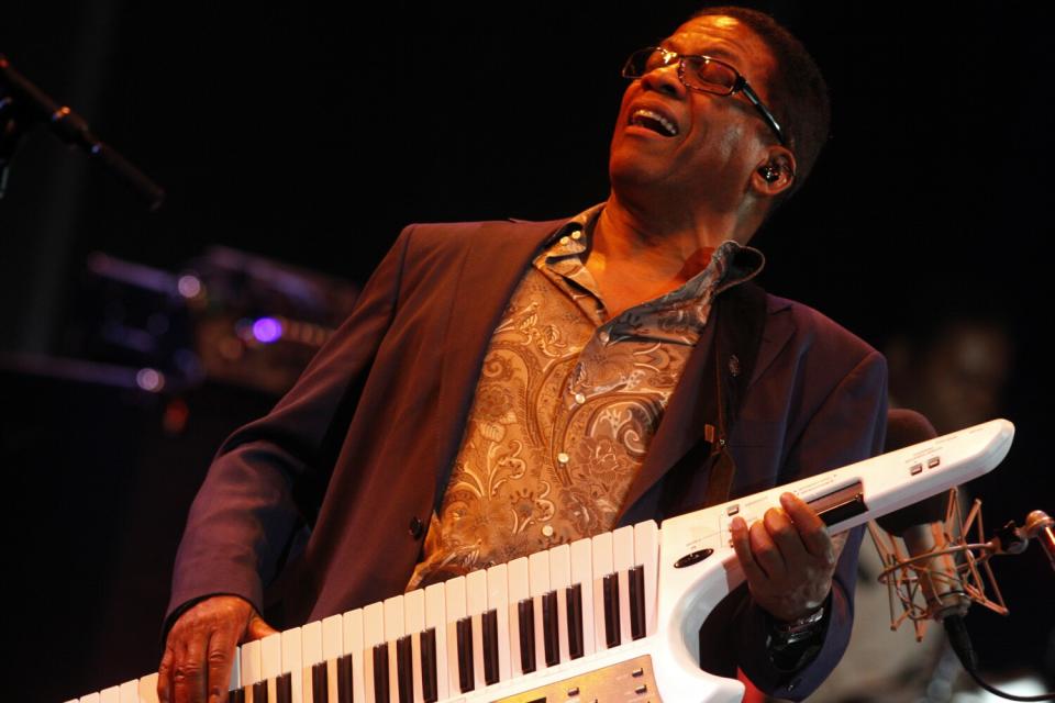 A man plays the keytar onstage.