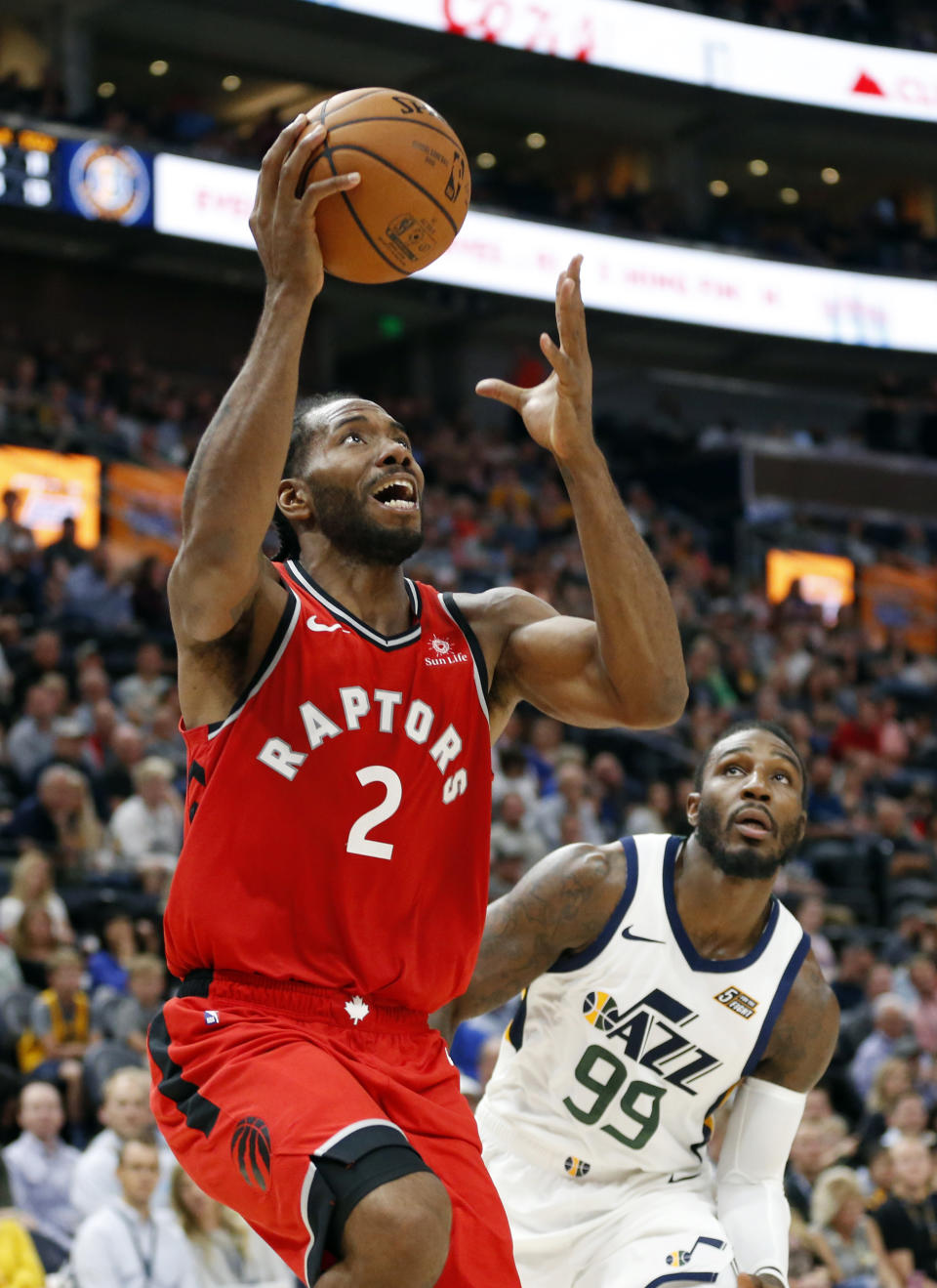 FILE - In this Oct. 2, 2018, file photo, Toronto Raptors forward Kawhi Leonard (2) goes to the basket as Utah Jazz forward Jae Crowder (99) looks on in the first half of an NBA preseason basketball game, in Salt Lake City. The NBA season begins Tuesday night, Oct. 16. (AP Photo/Rick Bowmer, File)