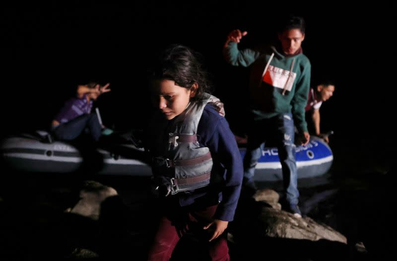 FILE PHOTO: Asylum-seeking migrants cross the Rio Grande river into the United States from Mexico