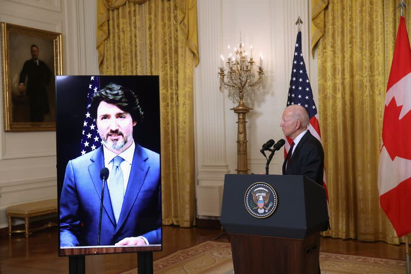 U.S. President Joe Biden looks on as Canada’s Prime Minister Justin Trudeau, appearing via video conference call, gives closing remarks at the end of their virtual bilateral meeting from the White House in Washington