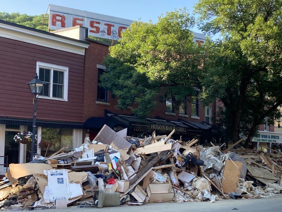 Rubble remains piled up July 20, 2023 in front of Hugo's Bar & Grill on Main Street, more than a week after floods devastated much of downtown Montpelier.
