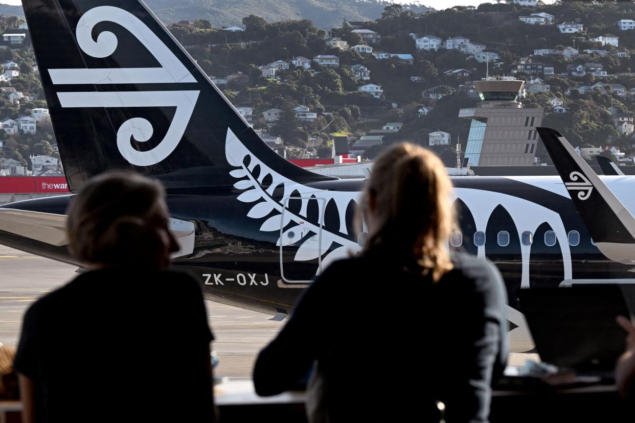 Passengers look at an Air New Zealand planes as they wait for their flight at Wellington Airport