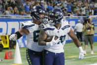 Seattle Seahawks running back Rashaad Penny (20) is greeted by Austin Blythe after Penny's 36-yard touchdown run during the second half of an NFL football game against the Detroit Lions, Sunday, Oct. 2, 2022, in Detroit. (AP Photo/Duane Burleson)