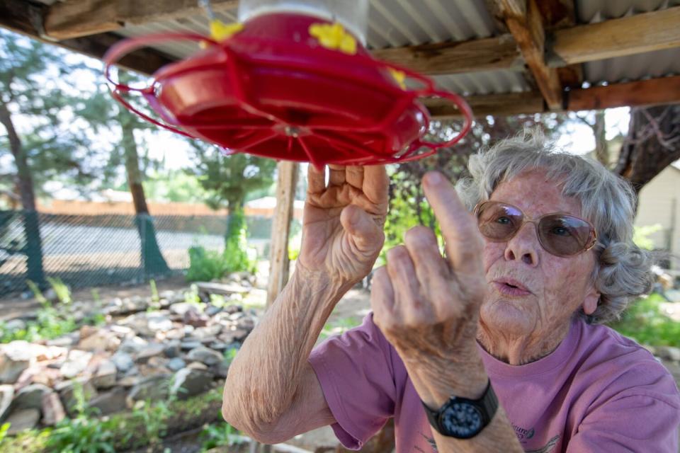 Joanne Heindel checks a hummingbird feeder.