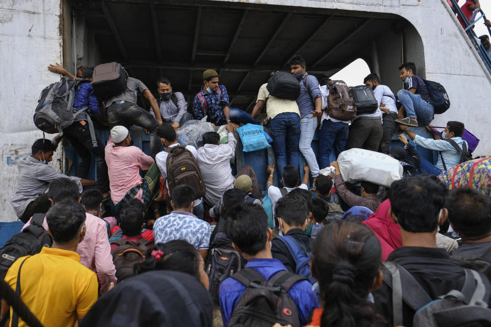 Thousands of people leaving for their native places to celebrate Eid-al-Fitr crowd the Mawa ferry terminal ignoring risks of coronavirus infection in Munshiganj, Bangladesh, Thursday, May 13, 2021. (AP Photo/Mahmud Hossain Opu)