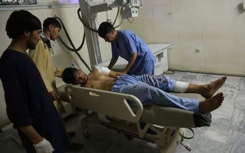 A wounded man receives treatment at a hospital after an explosion at wedding hall in Kabul - Credit: AP