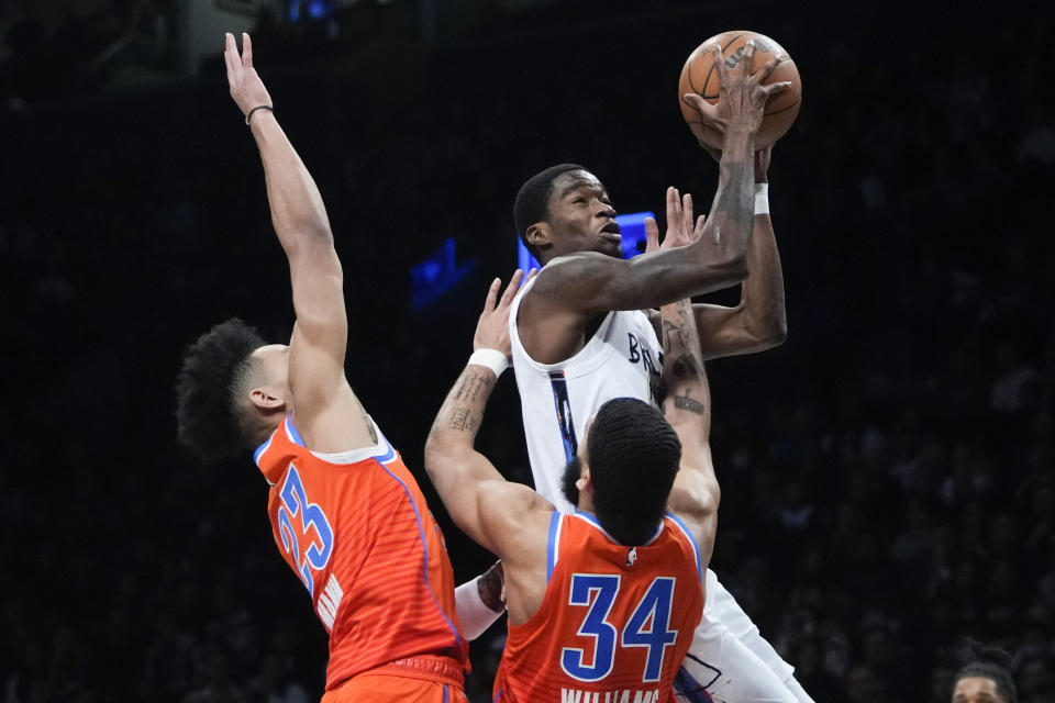 Brooklyn Nets' Edmond Sumner, top right, drives past Oklahoma City Thunder's Kenrich Williams (34) and Tre Mann (23) during the first half of an NBA basketball game Sunday, Jan. 15, 2023, in New York. (AP Photo/Frank Franklin II)