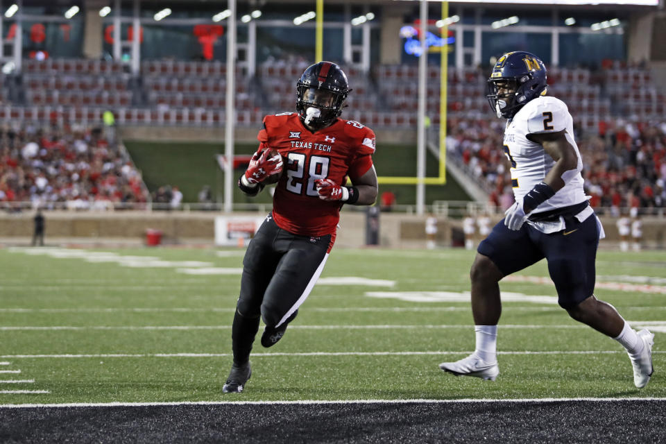 Texas Tech's Tahj Brooks (28) scores a touchdown next to Murray State's Tre Allen during the first half of an NCAA college football game Saturday, Sept. 3, 2022, in Lubbock, Texas. (AP Photo/Brad Tollefson)
