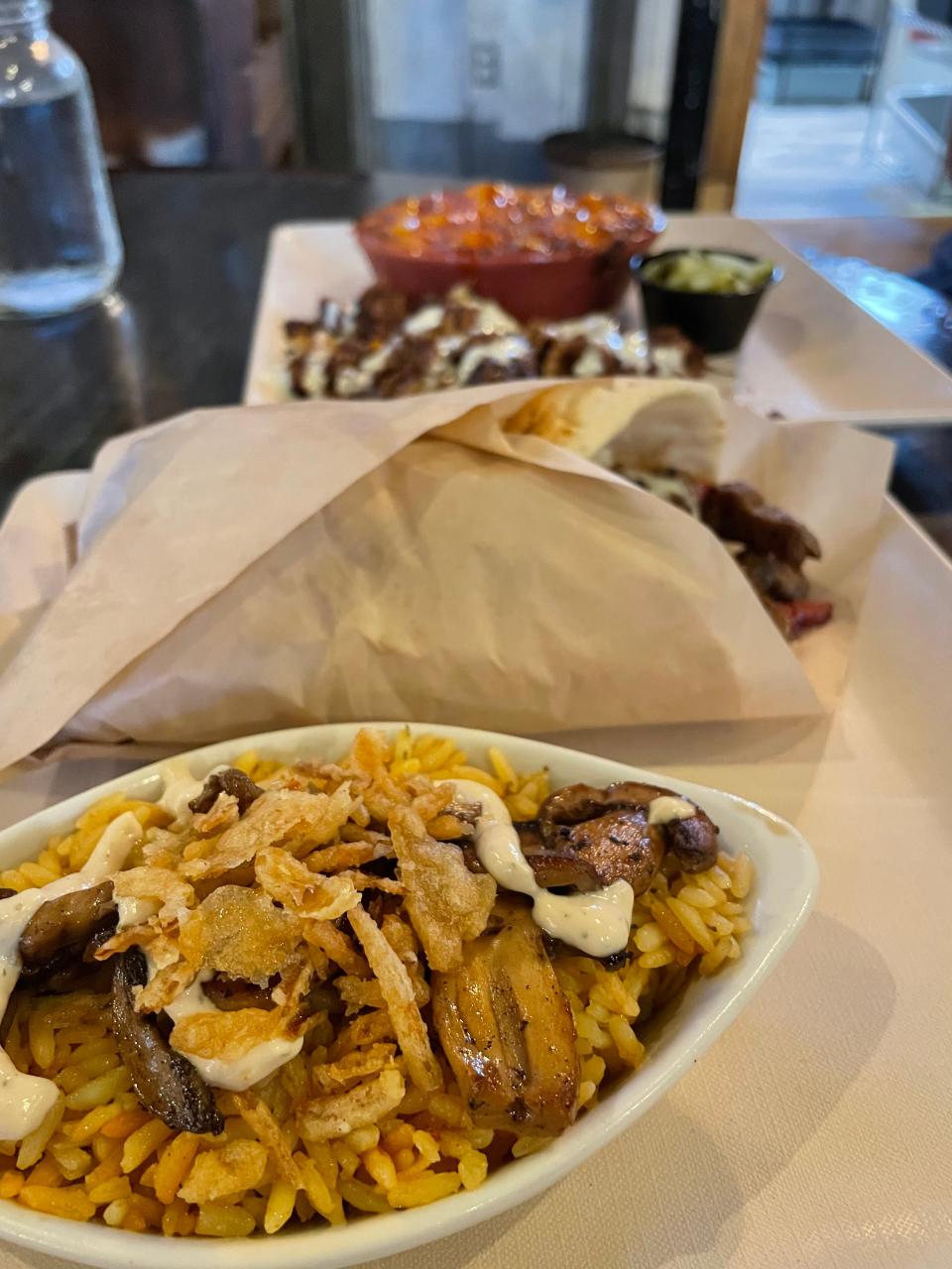Alé Rae’s Gastropub serves pub-style comfort foods with a chef’s touch. Pictured, from front to back: mushroom-butter rice pilaf, Gordo Steak & Cheese roll, pulled pork plate with a side of macaroni and cheese.