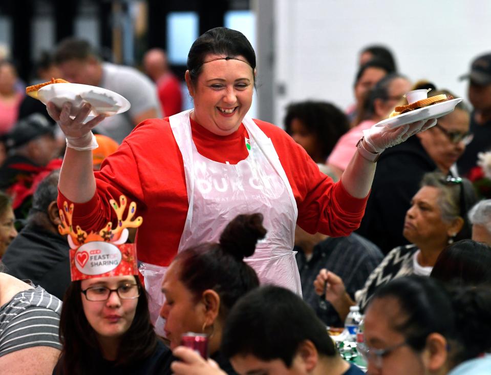 Stephanie Myers, a volunteer from Beltway Park Church, carries plates of food during Tuesday’s annual H-E-B Feast of Sharing at the Abilene Convention Center Dec. 5, 2023. This was the 19th year for the admission-free community dinner.