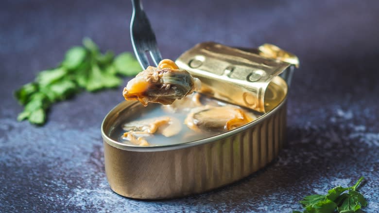 removing clam from can with fork