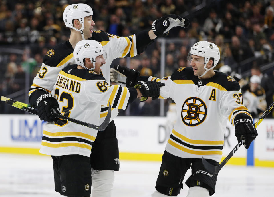 FILE - In this Feb. 20, 2019, file photo, Boston Bruins' Brad Marchand, front, celebrates with teammates Zdenoa Chara, back left, and Patrice Bergeron after scoring against the Vegas Golden Knights during the third period of an NHL hockey game in Las Vegas. The three veterans who hoisted the Stanley Cup after winning it all in 2011 are among the core Bruins who will host the St. Louis Blues Monday, May 27, 2019, in Game 1 of the Stanley Cup Final. (AP Photo/John Locher, File)