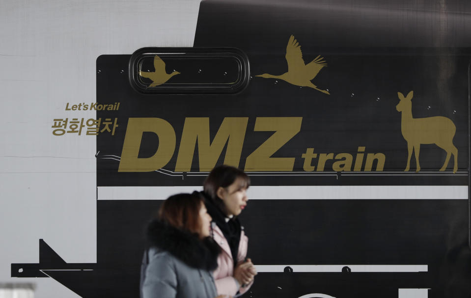 Visitors walk past near a train carrying letters "Peace train" and "DMZ train" at Imjingang Station in Paju, South Korea, Saturday, Nov. 24, 2018. South Korea said Saturday that the United Nations Security Council granted an exemption to sanctions that will allow surveys on North Korean railroad sections the Koreas want to connect with the South. (AP Photo/Lee Jin-man)