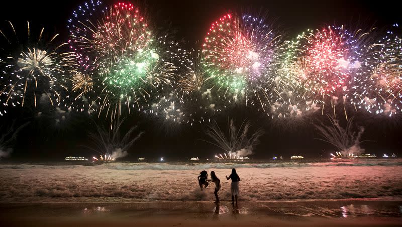 Children play as fireworks light up Copacabana Beach during New Year’s celebrations in Rio de Janeiro, Brazil, early Monday, Jan. 1, 2024.