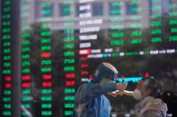 Worker in protective suit takes body temperature measurement of a woman inside the Shanghai Stock Exchange building, as the country is hit by a novel coronavirus outbreak, at the Pudong financial district in Shanghai