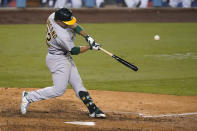Oakland Athletics' Ramon Laureano swings for a two-run home run during the ninth inning of the team's baseball game against the Los Angeles Dodgers on Wednesday, Sept. 23, 2020, in Los Angeles. (AP Photo/Marcio Jose Sanchez)