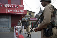 Indian paramilitary officer orders Kashmiri man to go back near a temporary barricade during restrictions in Srinagar Indian controlled Kashmir, Friday, Sept. 27, 2019. Residents in Indian-controlled Kashmir waited anxiously as Indian and Pakistani leaders were scheduled to speak at the U.N. General Assembly later Friday. (AP Photo/ Dar Yasin)