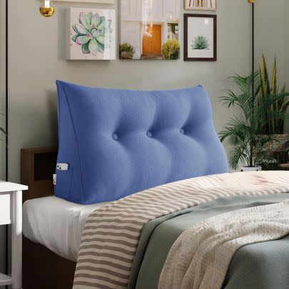 A wedge-shaped moveable headboard pillow