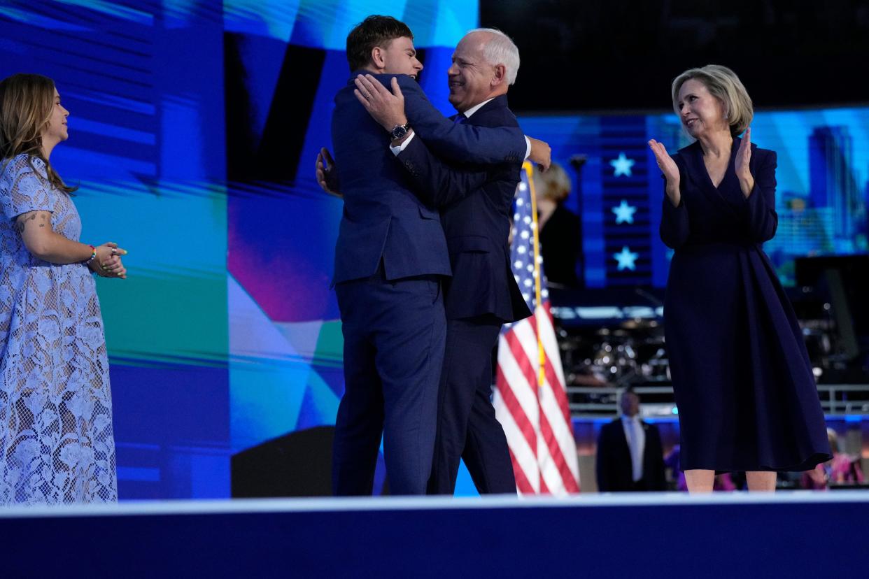 Aug 21, 2024; Chicago, IL, USA; Vice Presidential nominee Tim Walz hugs son Gus Walz during the third day of the Democratic National Convention at the United Center. Hope Walz is at left, Gwen Walz at right.