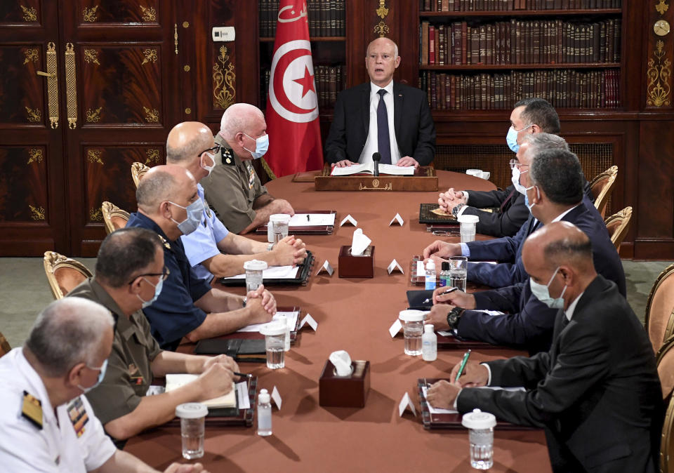 CORRECTING PHOTOGRAPHER BYLINE TO SLIM ABID - Tunisia's President Kais Saied, center, leads a security meeting with members of the army and police forces in Tunis, Tunisia, Sunday, July 25, 2021. Troops surrounded Tunisia's parliament and blocked its speaker Rached Ghannouchi from entering Monday after the president suspended the legislature and fired the prime minister following nationwide protests over the country's economic troubles and the government's handling of the coronavirus crisis. (AP Photo/Slim Abid)