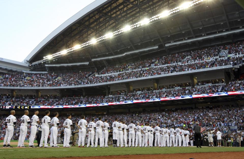 The Miami Marlins stand for the national anthem at the new Marlins Park before the Opening Day baseball game against the St. Louis Cardinals, Wednesday, April 4, 2012, in Miami. (AP Photo/Lynne Sladky)