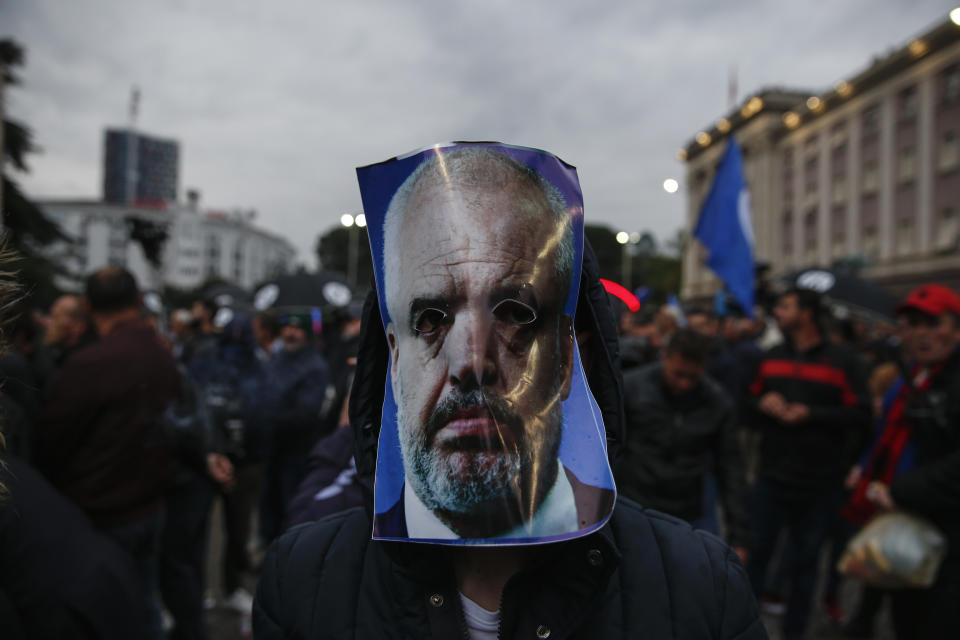 An opposition protester wears a mask depicting Albanian prime minister Edi Rama during an anti-government rally in Tirana, Albania, Saturday, April 13, 2019. Albanian opposition parties have gathered supporters calling for the government's resignation and an early parliamentary election. (AP Photo/Visar Kryeziu)