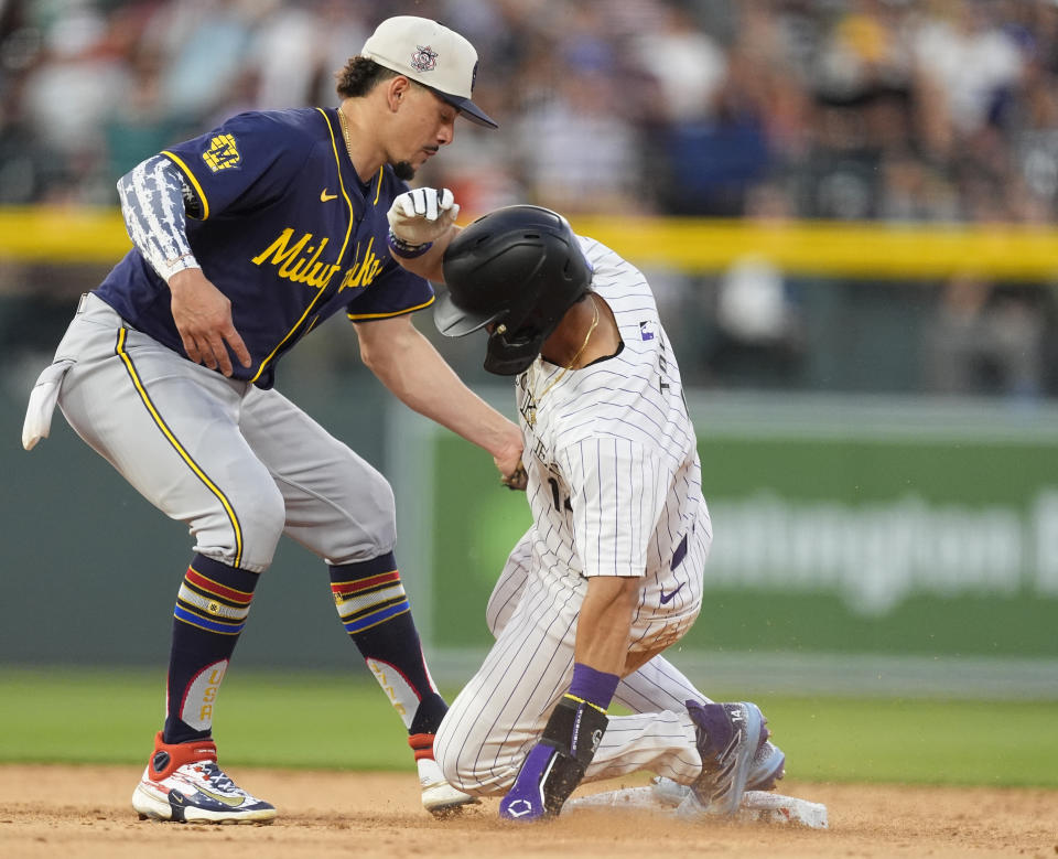 Milwaukee Brewers shortstop Willy Adames, left, tags out Colorado Rockies' Ezequiel Tovar, right, whotries to steal second base to end the seventh inning of a baseball game Thursday, July 4, 2024, in Denver. (AP Photo/David Zalubowski)