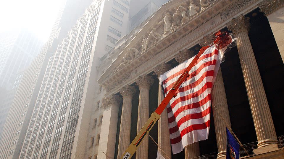 A huge United States flag is draped across the front of the New York Stock Exchange September 15, 2001 in preparation for its reopening on September 17 in New York City. The stock exchange had been closed since two hijacked commercial airliners were deliberately crashed into the World Trade Center's twin towers on September 11. - Chris Hondros/Getty Images