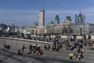 People eat their lunch along the south bank in London March 12, 2012.