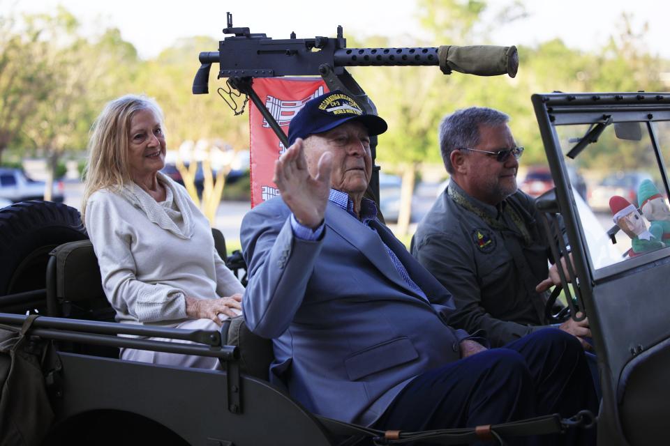 John L. Patton, with girlfriend Jean Pace, waves Tuesday as he arrives in a vintage World War II Willys Jeep driven by retired Army Col. Alfred Pantano at a ceremony at the St. Johns County administration building.