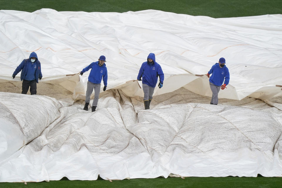 New York Mets groundskeepers pull a tarp over the outfield at Citi Field as a baseball game between the New York Mets and the Atlanta Braves was postponed due to rain, Sunday, May 30, 2021, in New York. (AP Photo/Kathy Willens)