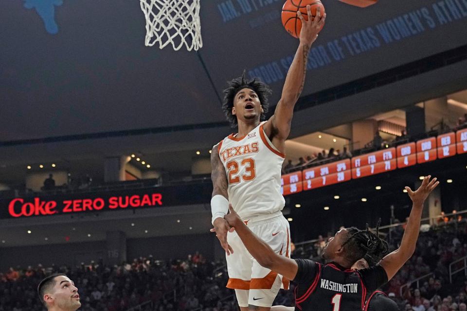 Texas forward Dillon Mitchell lays in a basket over Texas Tech's Lamar Washington on Saturday. Mitchell had his sixth double-double of the season with 16 points and 11 rebounds.