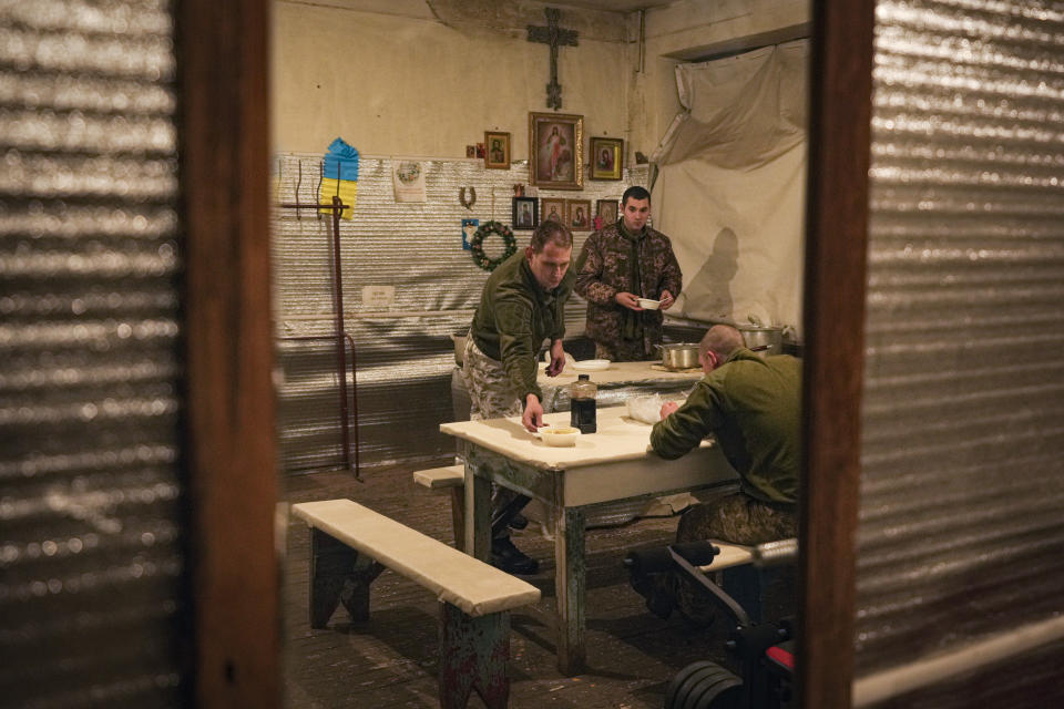 Ukrainian serviceman Ivan Skuratovskyi, left, prepares to have lunch before patrolling a frontline position outside Avdiivka, Donetsk region, eastern Ukraine, Friday, Feb. 4, 2022. President Volodymyr Zelenskyy is balancing worries about a military invasion with fears that alarm-ringing could wreck Ukraine’s economy without hardly a shot fired, with a heightened awareness that Ukrainian public opinion is divided on how to handle the situation, especially when it comes to concessions toward pro-Russian separatists in the east. (AP Photo/Vadim Ghirda)
