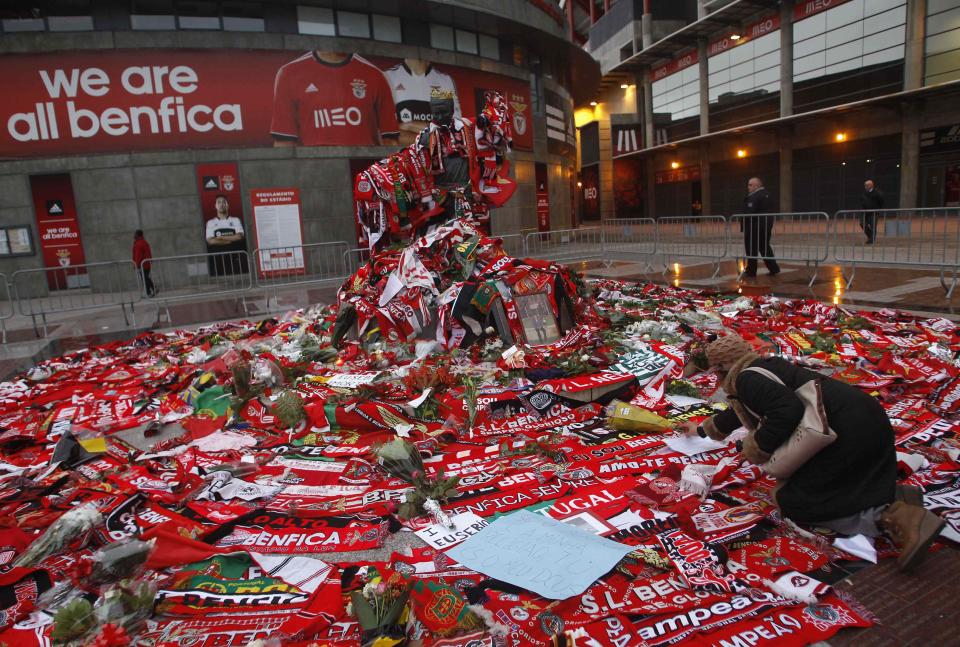 A woman places flowers at the Eusebio monument at Luz stadium in Lisbon January 6, 2014.