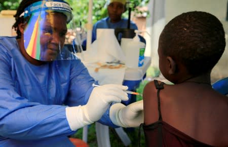 FILE PHOTO: Ugandan health worker administers ebola vaccine to a child in Kirembo village