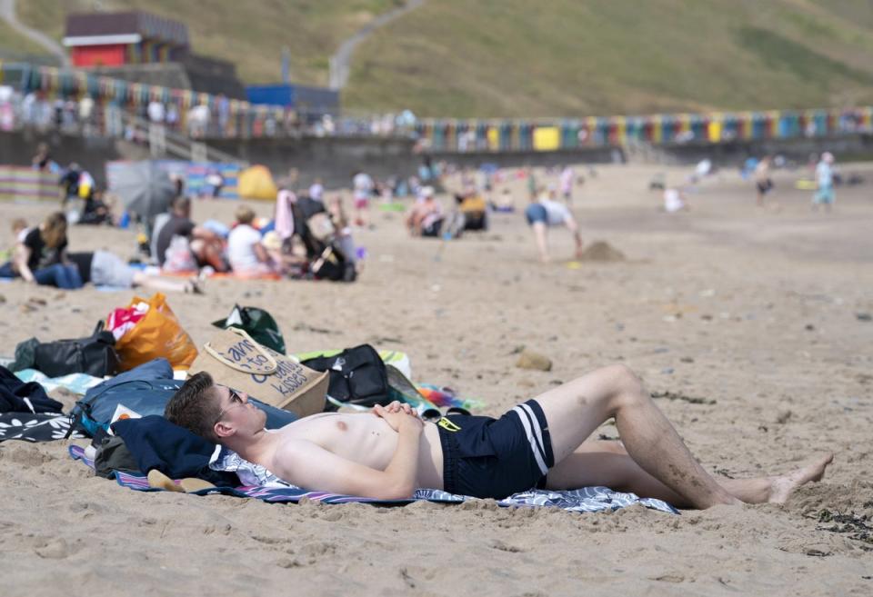 People enjoy the hot weather on Whitby beach in Yorkshire (Danny Lawson/PA) (PA Wire)