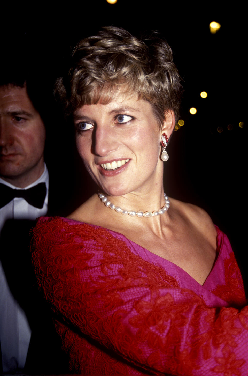 Diana, Princess of Wales, wearing a red and pink outfit with white pearls, at the Royal College of Music, 17th December 1991. (Photo by John Shelley Collection/Avalon/Getty Images)