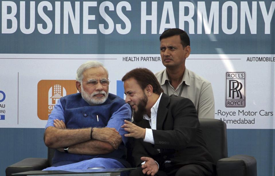 FILE- In this Feb. 7, 2014 file photo, Gujarat state Chief Minister Narendra Modi, left, listens to Zafar Sareshwala, a Muslim businessman who runs a BMW dealership in Ahmedabad, during an inaugural event of a three-day conclave on business harmony in Ahmadabad, India. Sareshwala said he was a staunch opponent of Modi after the 2002 riots but was eventually won over after meeting him and seeing the results of his infrastructure campaign. To some, the man in pole position to be India’s next prime minister is a visionary reformer, while to others he’s an autocrat in bed with big business cronies. Perhaps nowhere are opinions of Narendra Modi more polarized than in Gujarat, the western state he’s led for more than decade and that is now touted as a model of prosperity for all of India to emulate. (AP Photo/Ajit Solanki, File)