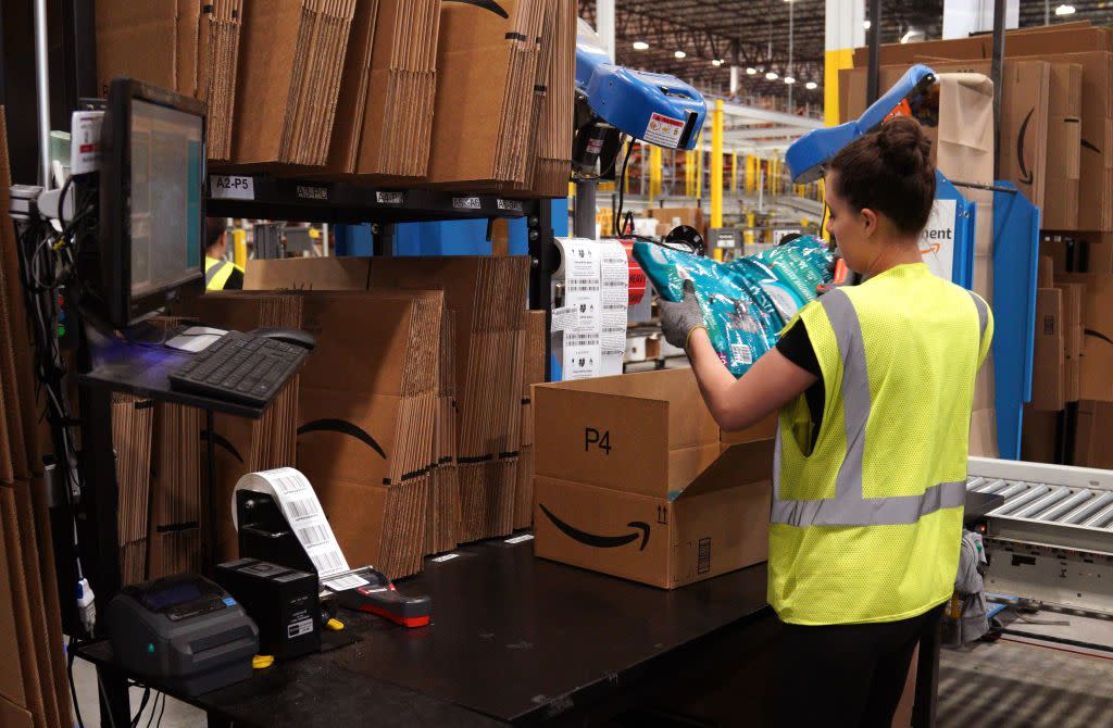 A worker packs cat food at the Amazon fulfillment center May 3, 2018 in Aurora, Colorado.