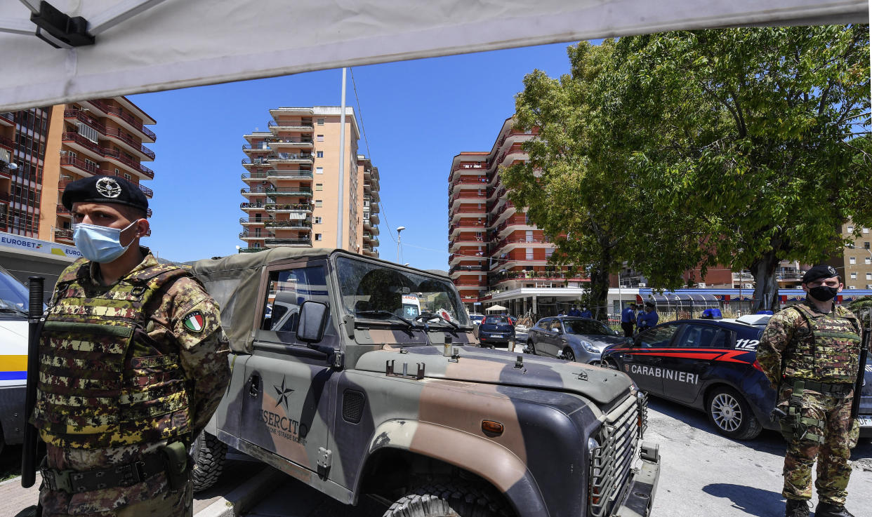 Italian police and Army personnel surround the 
