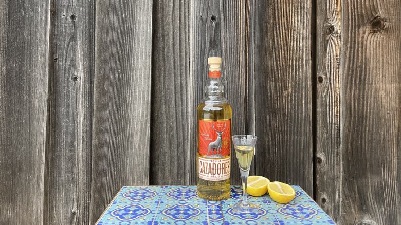 Cazadores Añejo and lemons on a blue table