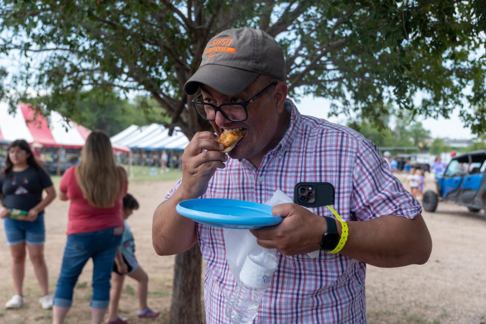 Aryn Corley samples a cheeseburger  Saturday at Friona's 17th annual Cheeseburger Festival.