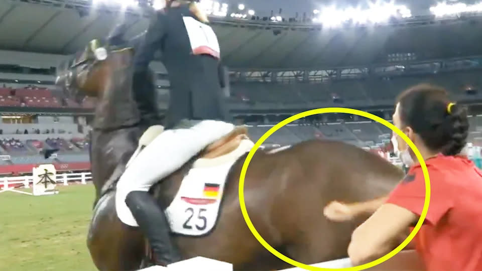 Pictured here, Germany's modern pentathlon coach Kim Raisner hits a horse in the back leg.
